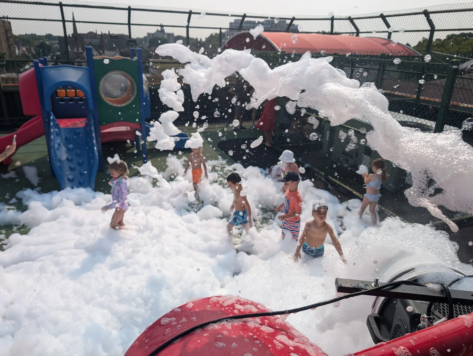 A foam cannon sending a stream of foam into an outdoor party area